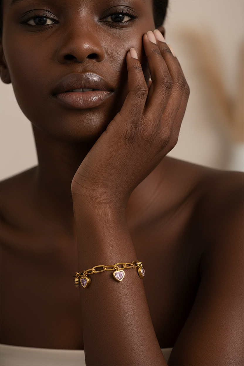 African woman wearing gold heart charm bracelet